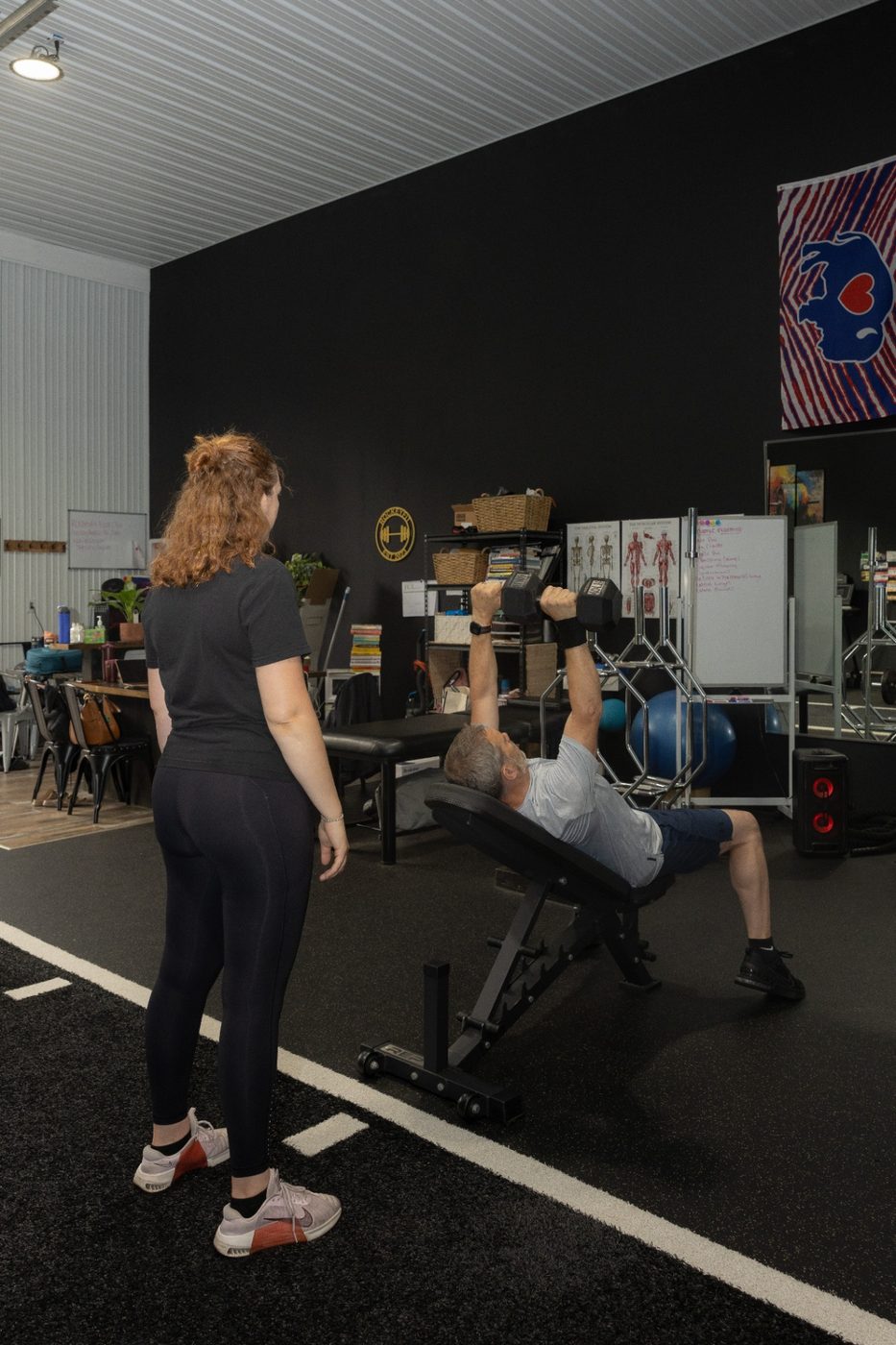 RockeyFit coach supervising a dumbbell press at the Hamburg, NY studio