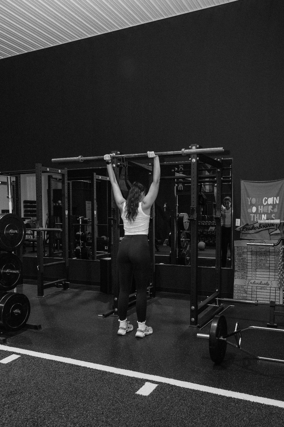 RockeyFit member pressing a barbell overhead, fueled by nutrition coaching