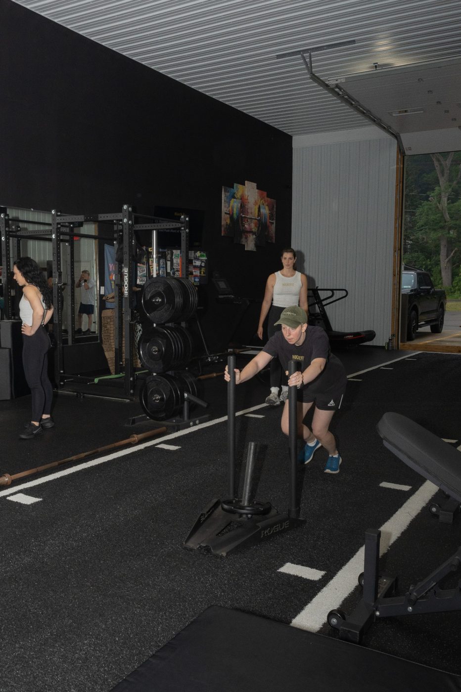 Member driving a loaded sled during a RockeyFit small group session